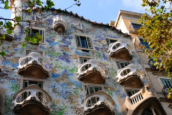 La fachada de la Casa Batlló, con sus balcones en forma de máscara y el trencadís de colores, bajo un cielo azul