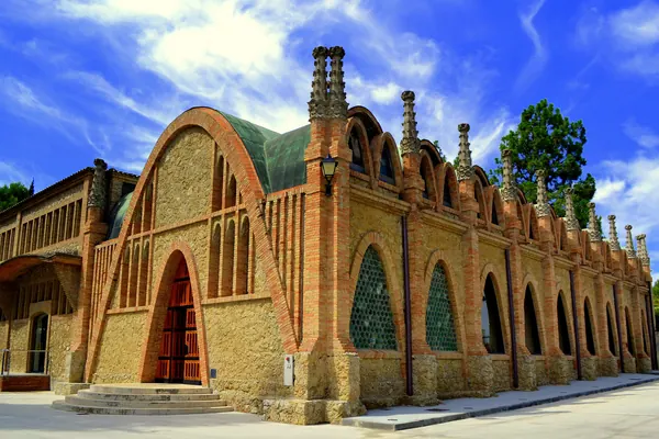 Una de las naves modernistas de Puig i Cadafalch en las bodegas de Codorníu, de ladrillo y piedra, bajo un cielo azul