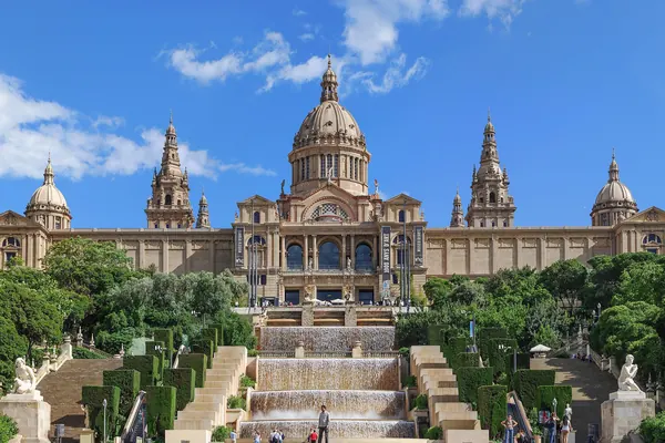El Palau Nacional de Montjuïc, sede del MNAC, sobre sus escalinatas y cascadas, con el cielo azul