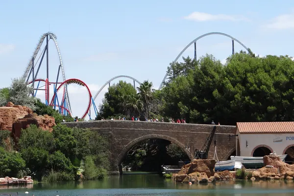 Las montañas rusas Shambhala y Dragon Khan de PortAventura Park, sobre el lago y un puente de piedra