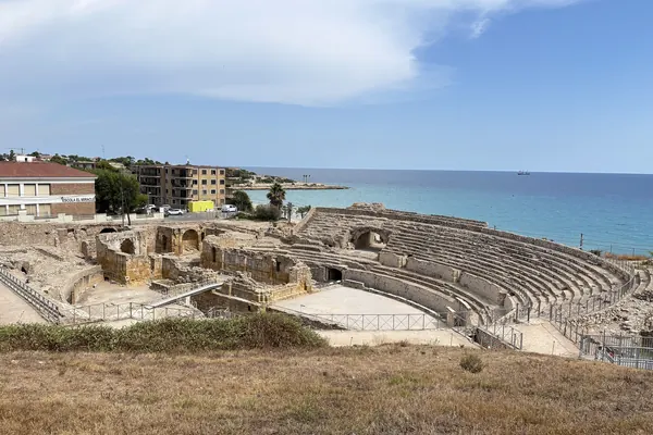 El anfiteatro romano de Tarragona junto al mar, con sus gradas de piedra y el agua azul al fondo