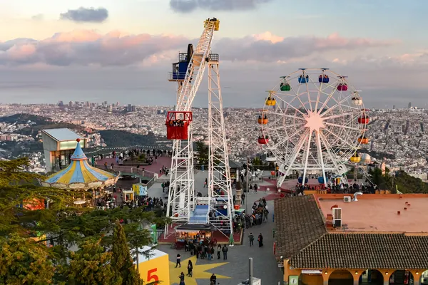 La noria y las atracciones del Tibidabo en lo alto de la montaña, con Barcelona a sus pies